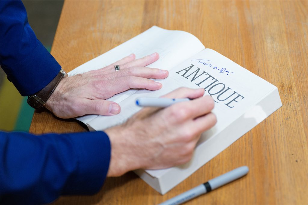 Seth Panitch's Hands Signing his book Antique